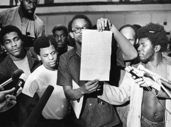 Inmates display letter signed by Kenneth Hardy promising no reprisals for the October 11, 1972 uprising at the D.C. Jail. (Photo Credit: Pete Schmick, Reprinted with permission of the DC Public Library, Star Collection, © Washington Post.)