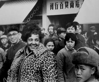 Black female journalist Ethel Payne stands with a smile on her face amidst a crowd in Shanghai, China while she was abroad reporting for the Chicago Defender in the 1970s.