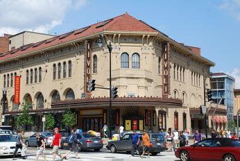 The revitalized Tivoli Theater in Columbia Heights, with tan walls and a red roof in an Italian architectural style. There is a large marquee, and signs with the word "Tivoli."