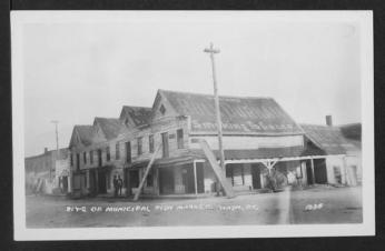  View of the Municipal Fish Market at the intersection of Water Street, 11th Street, and G Street SW. The roof of wood frame market building is painted with an advertisement reading GENUINE BULL DURHAM SMOKING TOBACCO. Circa 1917.