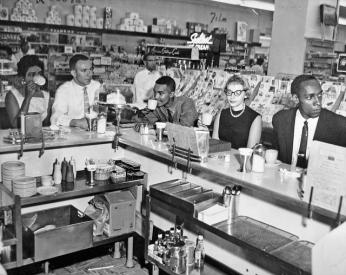 Non-violent Action Group members enjoy a cup of coffee at an Arlington Drug Fair lunch counter on June 23, 1960, one day after the counter was integrated. (Source: Washington Area Spark on Flickr.) Non-violent Action Group members enjoy a cup of coffee at an Arlington Drug Fair lunch counter on June 23, 1960, one day after the counter was integrated. (Source: Washington Area Spark on Flickr.)