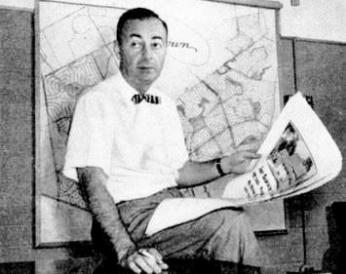 William Levitt posing with a map of his suburb
