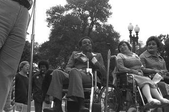 Brad Lomax, center, next to the activist Judy Heumann at a rally in 1977 at Lafayette Square in Washington. (Photo by HolLynn D'Lil)