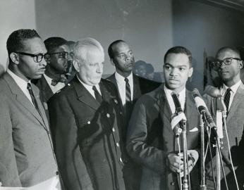 Walter Fauntroy speaks at March on Washington planning news conference in 1963, with Hobson standing behind him.