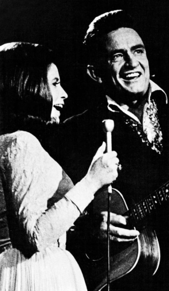 Johnny Cash and June Carter Cash, 1971. Image Source: Billboard via Wikimedia Commons. Johnny Cash and June Carter Cash performing together in 1971. Image Source: Billboard via Wikimedia Commons.