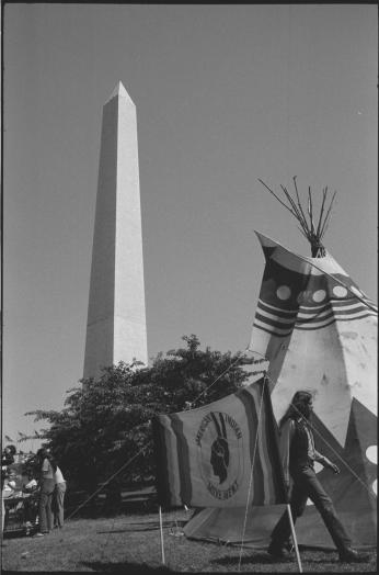 A tipi and the American Indian Movement (AIM) flag in front of the Washington Monument (Source: Wikimedia Commons)