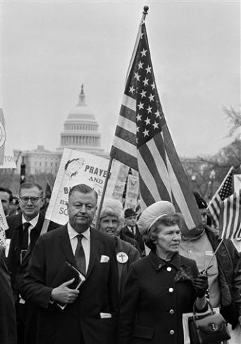 With Bible in hand, the Rev. Carl McIntire and his wife, Fairy McIntire, lead the "March for Victory" on Pennsylvania Avenue in Washington, D.C., April 6, 1970. McIntire said his parade was a demonstration for military victory in Vietnam. (AP Photo/Bob Daugherty)