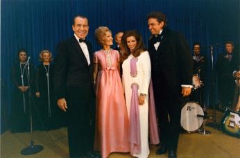 The Nixons and the Cashes pose for a photo on the evening that Cash performed at the White House. Image Source: National Archives.