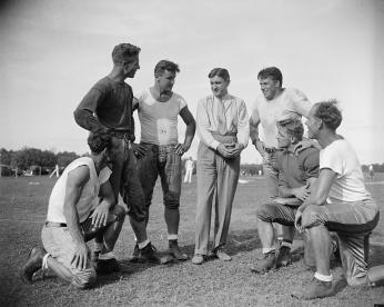 George Marshall, owner of the Washington Redskins, talks it over with some of his players, left to right: Wayne Millner, tackle, end, Charlie Malone, end,. Vic Carroll, Tackle,. George Marshall, Bill Young, Tackle, Ed Michaels, Guard, Jim Garber, Tackle,. 9/11/37