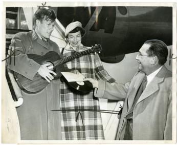 From left to right, Jimmie Dodd and his wife, Ruth, are presented with a record of "Washington" by James H. Simon.