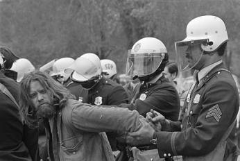 An anti-war protester is subdued by police in riot gear as they gather in front of the Justice Department, May 5, 1971. (AP Photo)