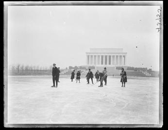 Black and white photo of people ice skating on the Reflecting Pool in January 1922.