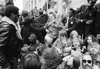 An employee of the Justice Department is helped over demonstrators blocking the entrance to the building in Washington, May 1, 1971 An employee of the Justice Department is helped over demonstrators blocking the entrance to the building in Washington, May 1, 1971