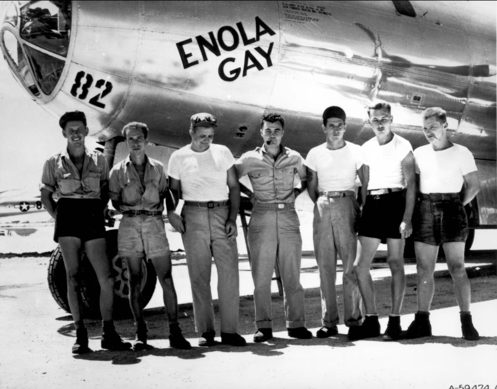 A crew of Air Force soldiers below a plane fuselage