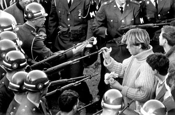  A protester inserts flowers into the rifle barrels of military police near the Pentagon.