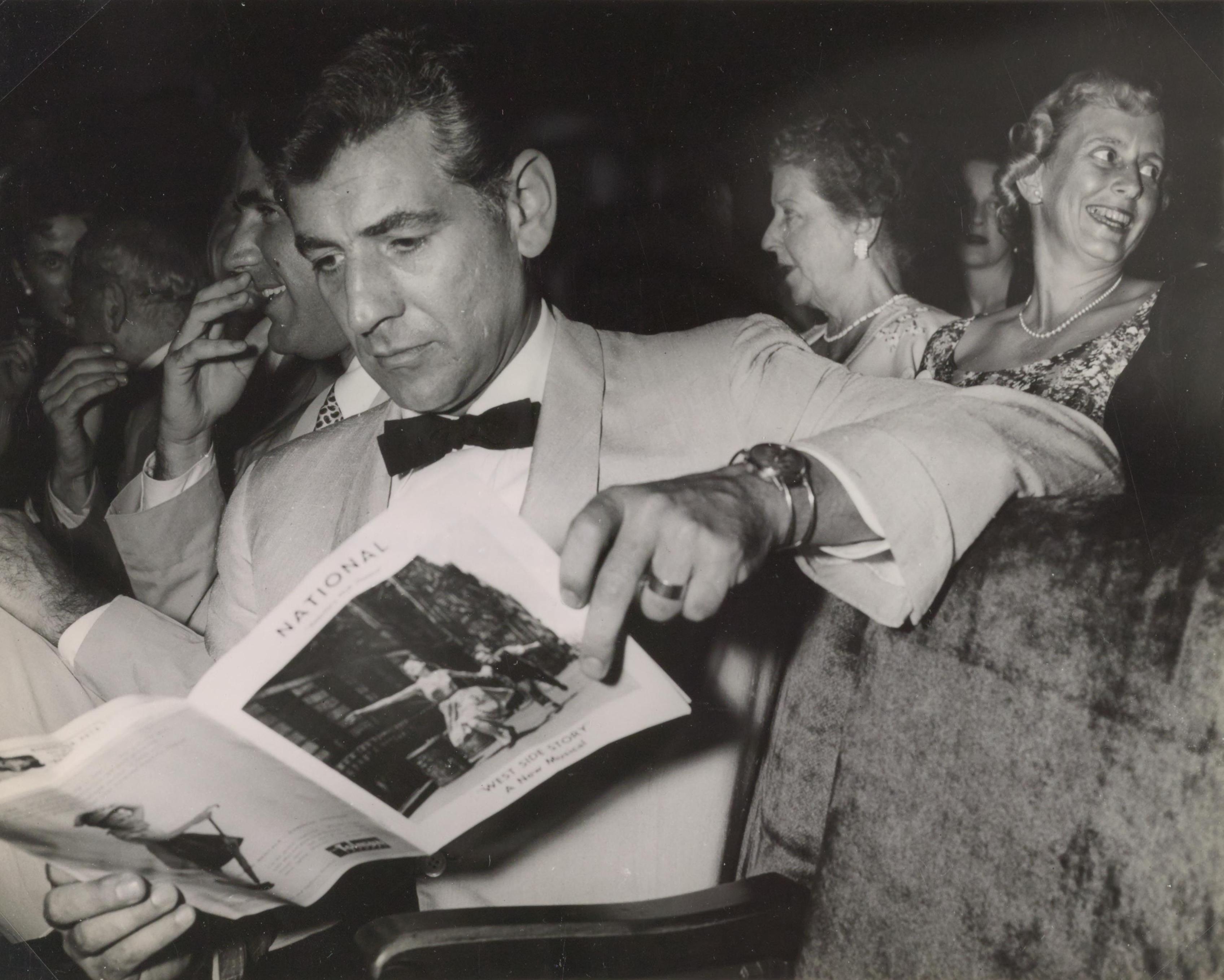 Leonard Bernstein reads playbill for West Side Story at the musical's premiere at the National Theater in Washington, DC on August 12, 1957. (Source: Library of Congress)