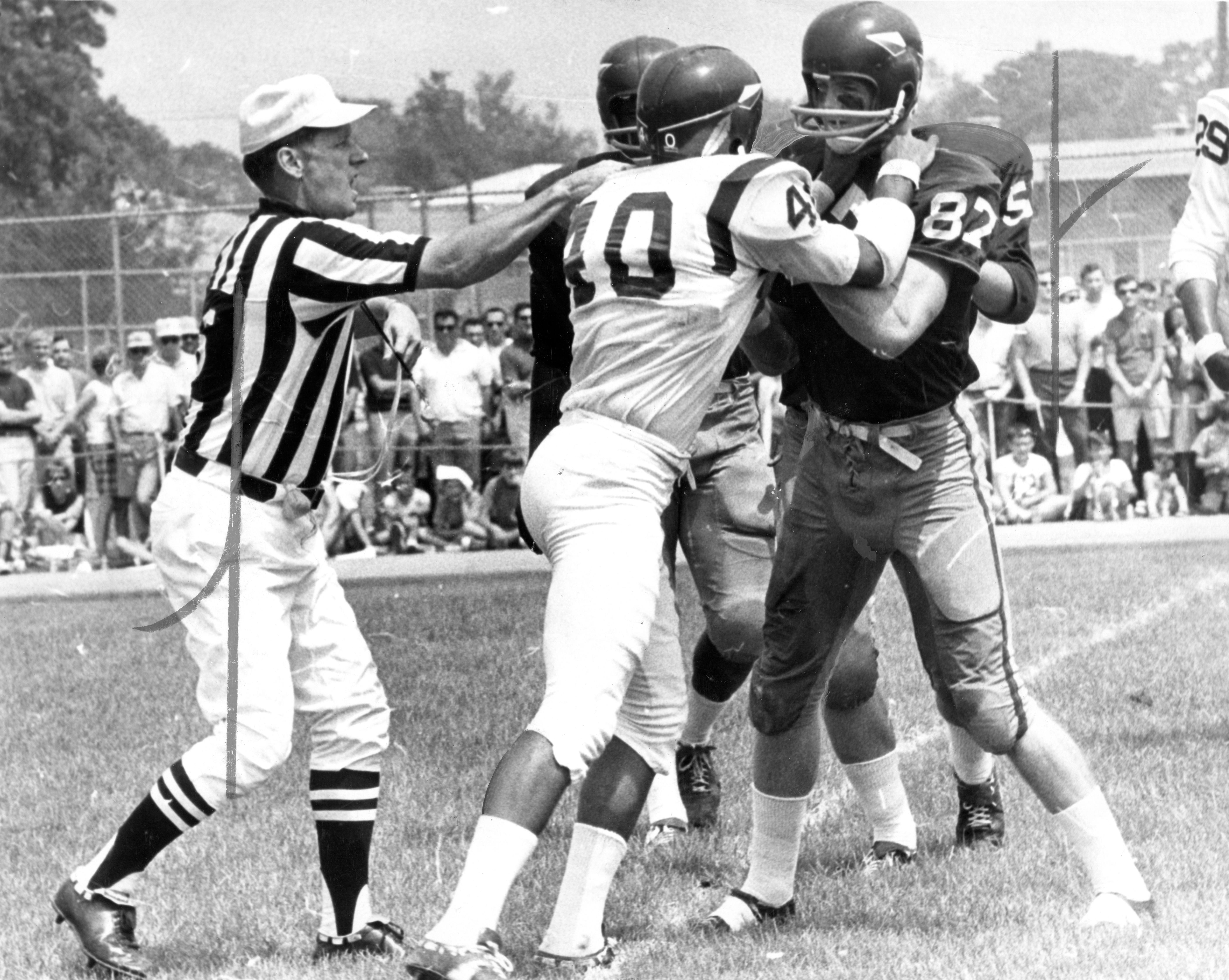 Jerry Smith grapples with a teammate as a referee tries to separate them.