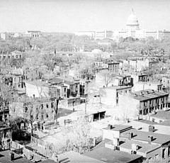 A view of Southwest from above. This is from pre-urban renewal circa 1939. Crowded streets full of buildings are in the foreground and the Capitol building is visible in the background. 